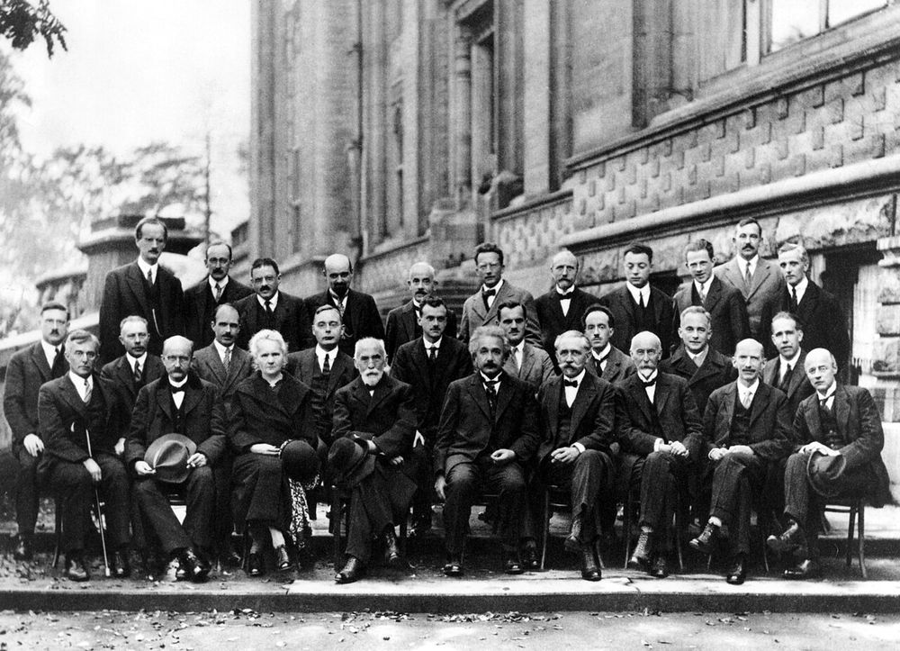 Black and white group photograph of the 1927 Solvay Conference: about thirty physicists in three rows outside a building